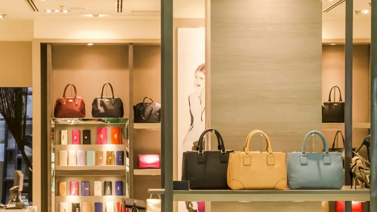 Chic boutique with a variety of handbags and shoes elegantly displayed on shelves.